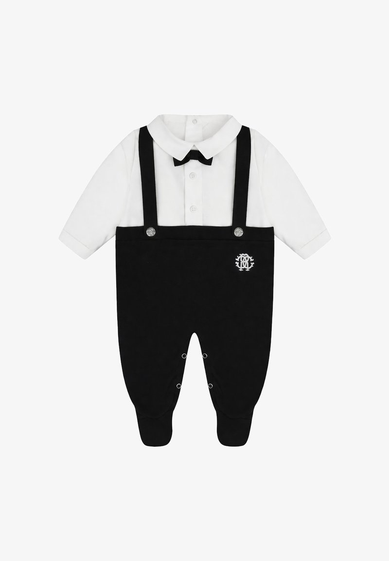 Grenouillère blanche à manches longues pour bébé avec pantalon style bretelles noir, nœud papillon noir fixé, boutonnage devant et pressions aux jambes.