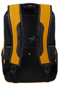 Zaino nero e giallo con retro e spallacci imbottiti, dotato di tessuto in rete, fibbie regolabili e un logo distintivo sulla parte anteriore inferiore.