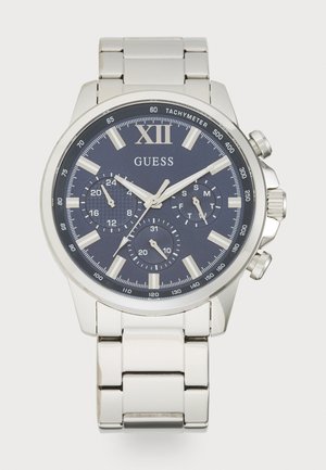 Montre en acier inoxydable argenté avec un cadran bleu marine, fonctions chronographe, index horaires blancs et bracelet poli.