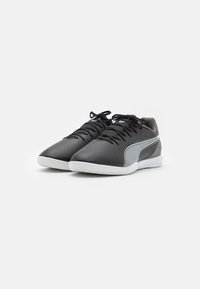 Zapatillas deportivas negras con parte superior de cuero liso, acentos grises texturizados y suela de goma blanca. Presenta cordones negros y un diseño elegante.