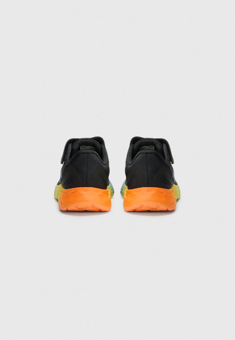Zapatillas deportivas negras con una suela en degradado de naranja y verde, que presentan un diseño de ajuste ceñido y detalles de tela en la parte trasera y el talón.