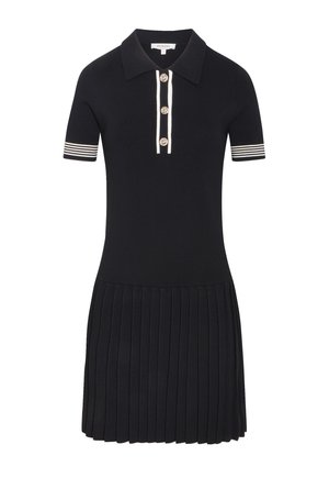 Abito polo nero a maniche corte con polsini a righe bianche, gonna plissettata, tre bottoni dorati sulla patta anteriore e colletto.