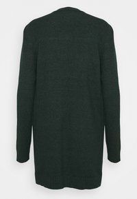 Larga chaqueta de punto de color verde oscuro, hecha de un suave tejido de punto. Presenta un corte relajado, mangas largas y un dobladillo y puños acanalados. No tiene cierres visibles.