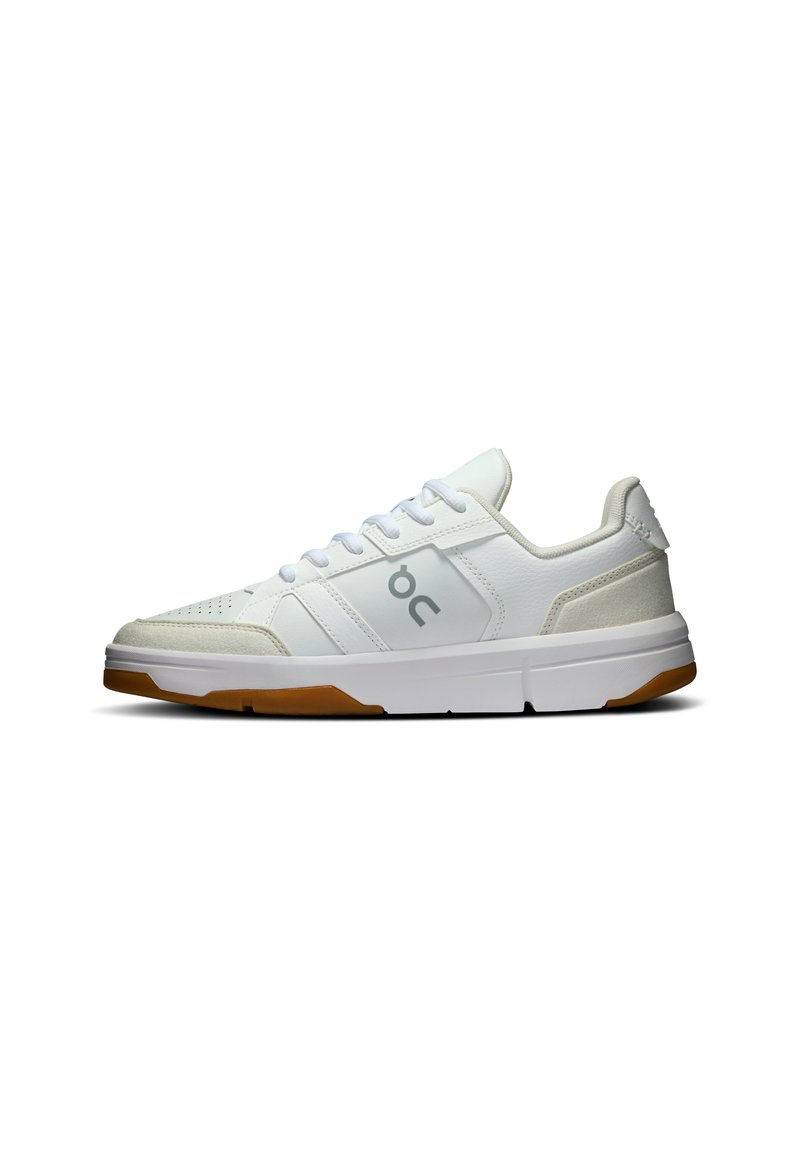 White athletic shoes with suede and mesh panels, featuring a rounded toe, lace-up front, and gum rubber outsole. Logo displayed on side.