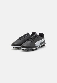 Botas de fútbol negras con una parte superior texturizada, acentos blancos y un diseño de perfil bajo. Cuenta con un cierre con cordones y clavos moldeados para tracción.