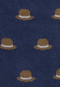 Nawinowy materiał w wzór z małymi brązowymi kapeluszami z białymi pasami, równomiernie rozmieszczonymi na teksturowanej powierzchni.