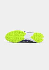 Scarpa sportiva con una suola testurizzata di un vivace giallo neon, intersuola bianca e un design snello con accenti viola e verde.