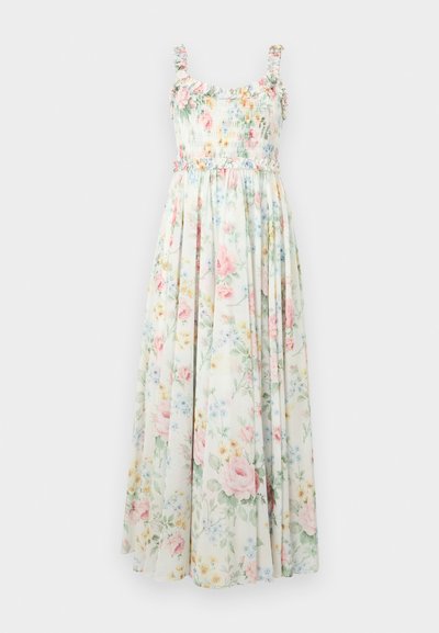 Florale maxi-jurk met een geregen lijfje, franje schouderbanden en pastelkleurige rozen- en blauwe bloemenpatronen op een lichte achtergrond.