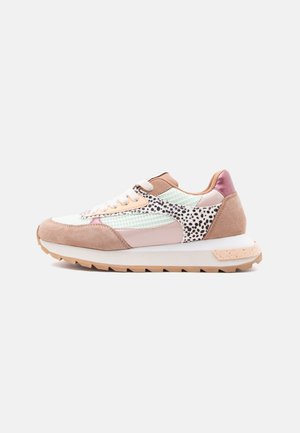 Sneaker basso con mesh bianco, pannelli in camoscio rosa e beige, motivo a macchie nere, lacci bianchi e suola in gomma beige, vista laterale su sfondo bianco.