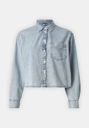 Light blue denim cropped shirt with long sleeves, a button-down front, and a single chest pocket. Features a collared neckline and frayed hem.