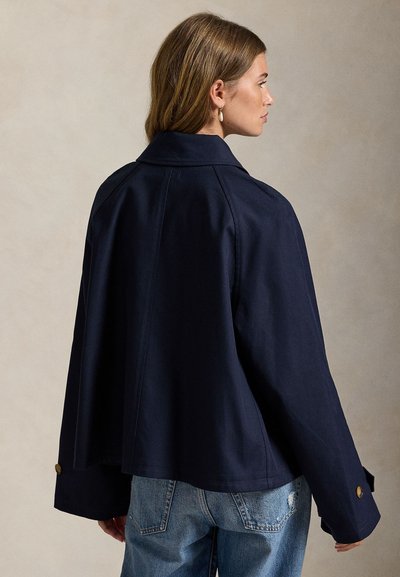 Μπλε ρούχα βαμβακερό μπουφάν με δομημένο γιακά, άνετη εφαρμογή και φαρδιά μανίκια. Διαθέτει κουμπιά χρυσού τόνου στις μανσέτες και καθαρό σχέδιο πίσω.