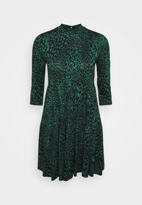 Grön leopardmönstrad klänning med trekvartsärmar, hög halsringning och utsvängd kjol. Tillverkad av lättviktigt tyg med en slät yta.