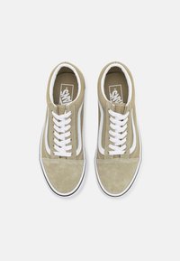 Zapatillas de ante verde claro con cordones blancos y franjas laterales, puntera redondeada y suela de goma negra en contraste. Logo en la plantilla.