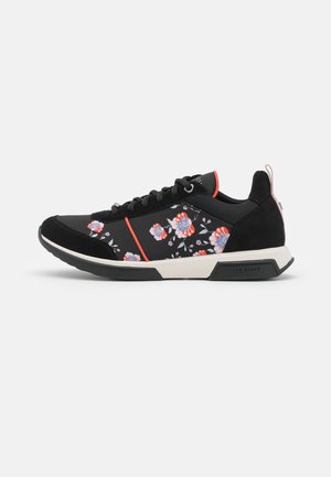 Baskets noires avec motif floral en rose et bleu, avec un talon en daim, des lacets noirs et une semelle intermédiaire blanche avec des accents.