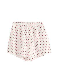 Pantaloni corti bianchi in cotone con una cintura elastica arricciata, caratterizzati da un motivo di piccoli cuori rossi su tutto il tessuto. L'orlo è arrotondato ai bordi.