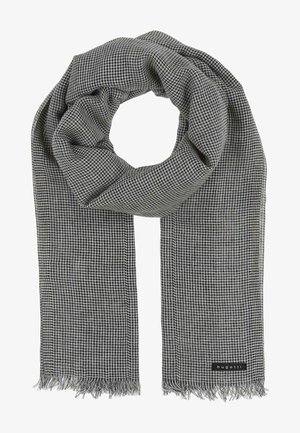 Schwarz-weiß kariertes Tuch aus einem weichen Stoff, mit fransigen Kanten und einem angenähten Etikett an einem Ende. Rund geformt, wenn es drapiert wird.