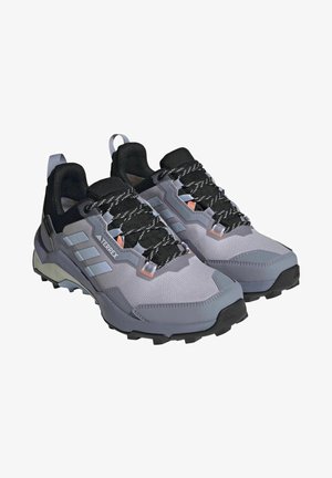 Chaussures de trail légères grises avec accents noirs, tige en synthétique texturé, lacets multicolores et semelle extérieure noire robuste pour une bonne traction.