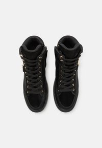 Svarta hög-top sneakers i mocka och mesh, med guldfärgad detaljer, platta snörning och vadderat ankelskydd. Slät texturerad sula.