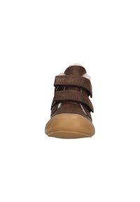 Brun tumlingesko med to velcro-stropper, blødt indre for og gummisål. Afrundet tå og syninger giver detalje.