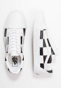 Baskets blanches avec un motif damier noir et blanc sur les côtés, bout rond, semelle plate blanche et lacets blancs. Cuir texturé et tissu.