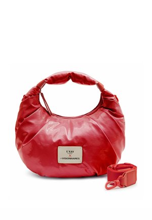 Sac à main en cuir rouge arrondi avec poignée courte et bandoulière assortie amovible, doté d'une plaque métallique de la marque à l'avant.