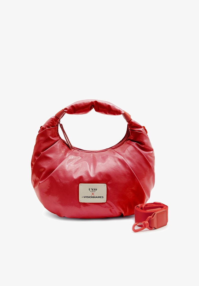Sac à main en cuir rouge arrondi avec poignée courte et bandoulière assortie amovible, doté d'une plaque métallique de la marque à l'avant.