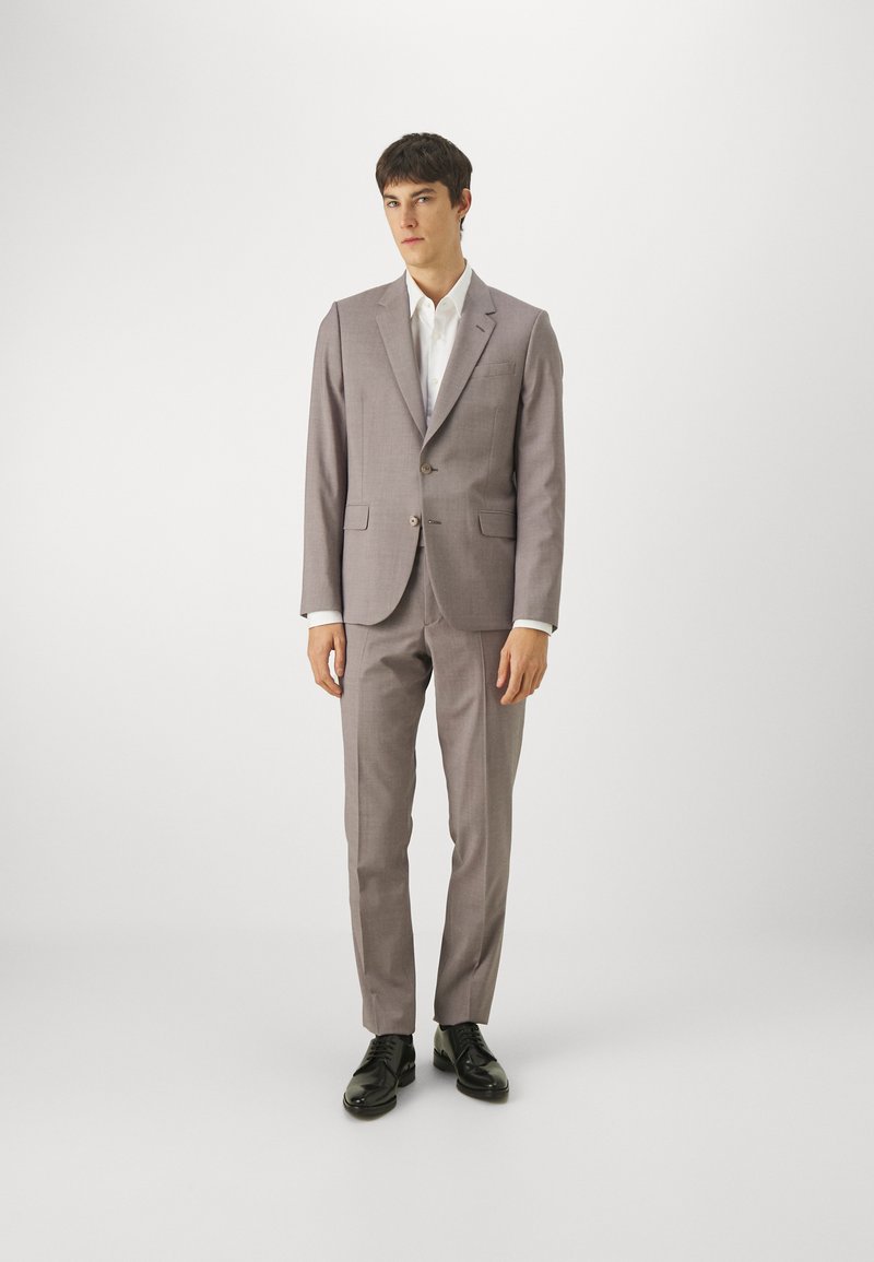 Costum gri deschis cu un sacou cu două nasturi și pantaloni drepți. Cămașă albă subțire, asortată cu pantofi negri eleganți. Textură fină.