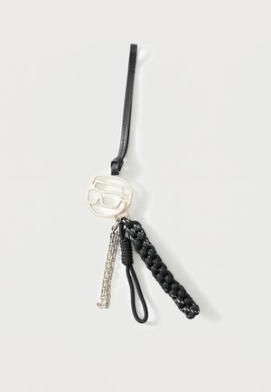 Zwarte leren polsband met zilveren bedeltje in de vorm van een zonnebril, een zilveren ketting en twee zwarte, getextureerde koorden bevestigd.