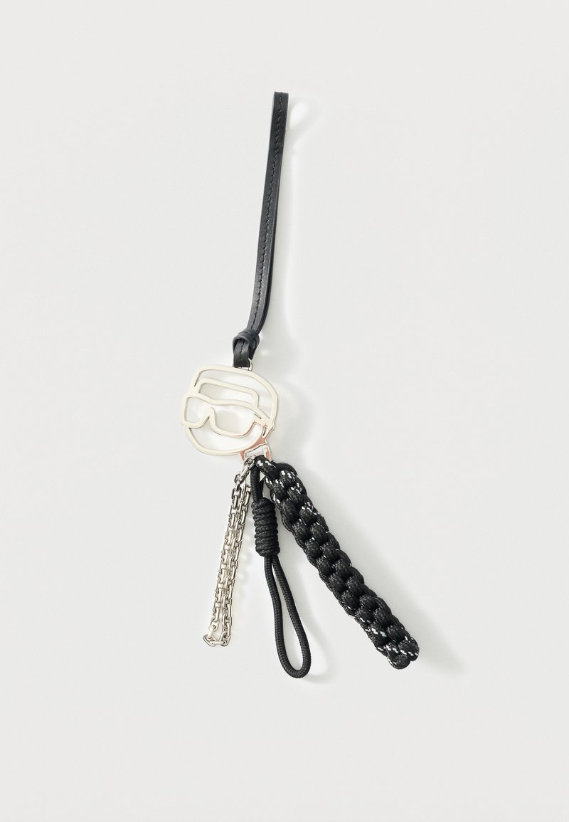 Μαύρο δερμάτινο λουράκι καρπού με ασημένιο γοητευτικό στοιχείο σε σχήμα γυαλιών ηλίου, ασημένια αλυσίδα και δύο μαύρα υφασμένα κορδόνια προσαρτημένα.