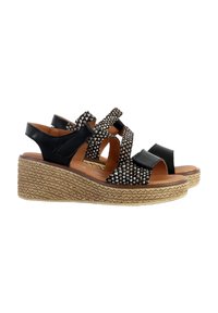 Sandales à semelle compensée noires avec des brides cloutées et du cuir lisse, dotées d'une semelle en jute tressé, d'un design à bout ouvert et d'une sangle à la cheville confortable.