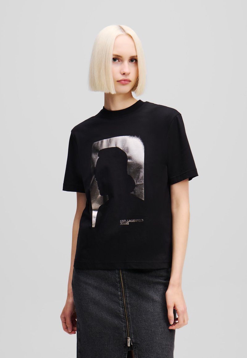 Melnas kokvilnas T-krekls ar metālisku sudraba kontūru grafiku priekšpusē, ar apaļu izgriezumu un īsām piedurknēm.