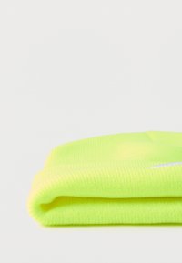 Neon žuta pletena kapa, mekana tekstura, s obrubljenim rubom i srebrnim logotipom. Pažljivo složena na bijeloj pozadini.