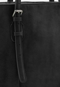 Sac à main en cuir noir avec une surface texturée, une bandoulière réglable avec boucle et des bords lisses. Design simple, sans motifs ni accents en matériel.