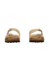 Beige sandaler med to justerbare remme, formet fodseng og tekstureret brun sål. Minimalistisk design, velegnet til afslappet brug.