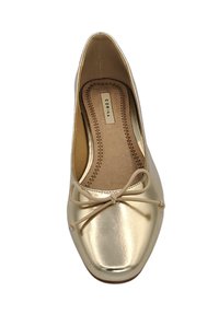 Ballerines dorées avec une finition brillante, ornées d'un nœud sur le devant, et dotées d'une semelle intérieure rembourrée avec un détail de bordure cousu.
