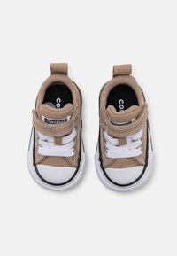 Beige Segeltuch-Sneaker mit weißen Schnürsenkeln, schwarzen Akzenten, Gummispitze und Fersenlasche. Klassisches Low-Top-Design mit kontrastierenden Nähten.