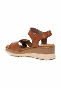 Sandalias de cuña de cuero marrón con dos correas ajustables, una plantilla de corcho y una suela de goma con un patrón de zigzag.