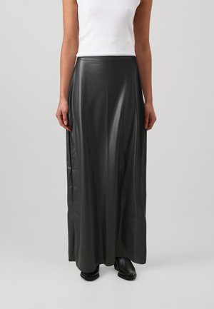 Black faux leather maxi skirt with a smooth texture, high waist, and side slits. Paired with a white sleeveless top and black shoes.