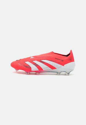 Red soccer cleat with a textured upper, white stripes, and a low-profile design. Features conical studs for traction and a snug fit.