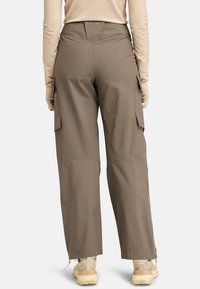 Cargo broek in gedempt bruin, met een hoge taille, zijzakken en een relaxte pasvorm. Gemaakt van lichtgewicht materiaal met zichtbare stikseldetails.