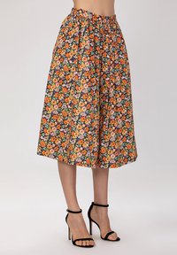 Jupe midi fleurie ornée de fleurs orange vif, roses et vertes sur fond noir, avec une taille élastique et une coupe ample.