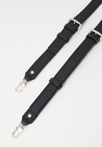 Zwarte leren band met een gestructureerde afwerking, voorzien van zilverkleurige hardware, verstelbare gespen en clipvergrendelingen voor een veilige bevestiging.