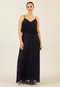 Marineblaues Maxikleid mit Falten, spaghettiartigen Trägern, geschichteter Oberseite und einem fließenden Rock; leichtes Material mit glatter Textur.
