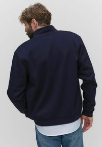 Mörkbl�å sweatshirt med hög krage, långa ärmar, ribbade cuffs och fåll; slät textur; enkel design utan mönster eller accenter.