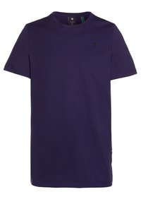 T-paita, jossa on lyhyet hihat ja pyöreä kaula-aukko, laivastonsininen, pieni musta logo vasemmassa rinnassa ja tagi kaulus sisäpuolella.