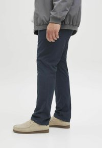 Marineblauwe broek van katoen met een recht model. Gemaakt in combinatie met beige suède schoenen en een grijze jas. Eenvoudige en functionele uitstraling.