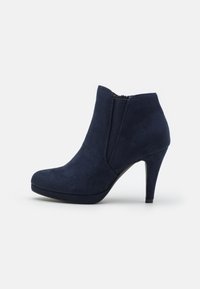 Marineblaue High-Heel-Stiefeletten aus weichem Wildleder mit runder Zehenform und elastischen Seitenpaneelen für ein einfaches An- und Ausziehen.
