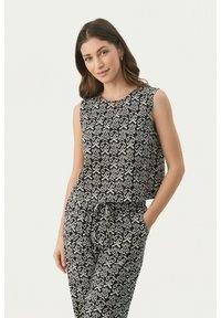Top senza maniche a fantasia bianca e nera con design floreale, abbinato a pantaloni coordinati con vita elastica e tasche laterali.
