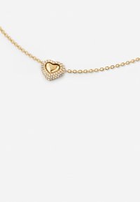 Gouden ketting met een hartvormige hanger versierd met heldere rhinestones en een gegraveerde binnenkant, elegant ontwerp.