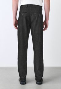 Schwarze Denim-Hosen in geradem Schnitt, mit zwei Gesäßtaschen mit Knopfverschlüssen und einem leicht strukturierten Stoff.